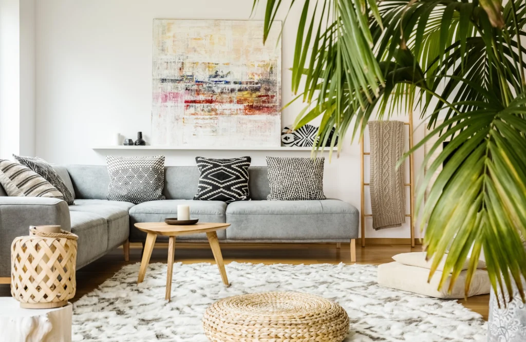 Welcoming sitting area with a gray sofa adorned with black and white patterned pillows, a wooden coffee table, and decorative elements, showcasing a stylish and organized home environment.