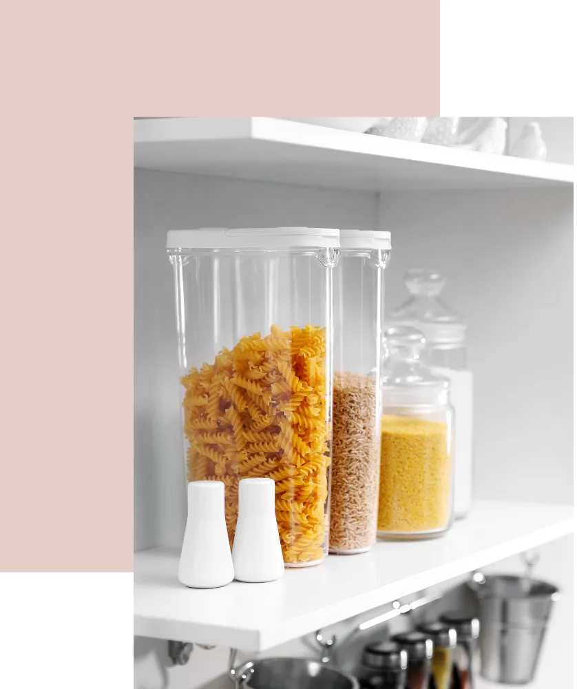 Clear storage containers with pasta and grains on a kitchen shelf, emphasizing organization and functionality for a harmonious home environment.